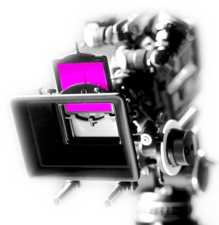Professional video camera setup with focus on the screen displaying pink light, presented in a high-contrast, partially blurred black and white style.